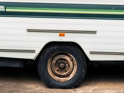 Older caravan with a flat tyre